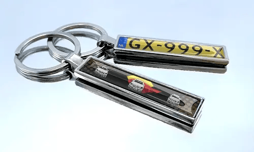 Metal comic keychain with car design and license plate detail