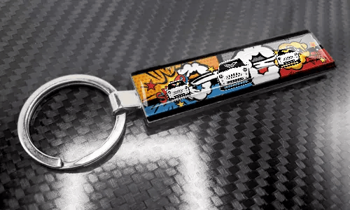 XL tenká klíčenka v komiksovém stylu s barevným designem poznávací značky na povrchu s uhlíkovou texturou