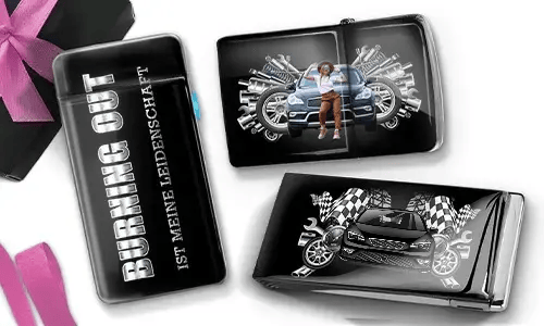 Drei schwarze Geldbörsen mit Auto-Designs. Eine trägt die Aufschrift „Burning Out ist meine Leidenschaft“, eine andere zeigt ein Auto mit Kolben und einer Person, und die dritte zeigt ein Auto mit karierten Flaggen und Kolben. In der Ecke liegt eine violette Schleife.