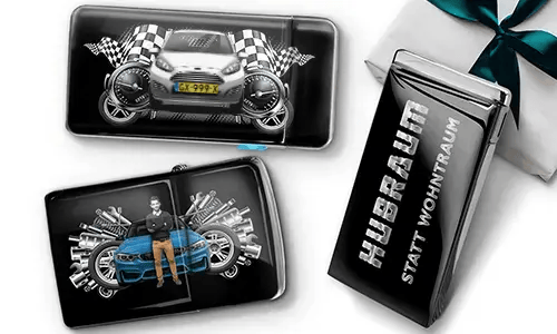 Geschenkset mit Auto-Themen-Metallbehältern, die Bilder eines grünen Sportwagens, karierten Flaggen und Motor-Motiven zeigen. Enthält ein Zigarettenetui mit der Aufschrift „Hubraum Statt Wohntraum“.