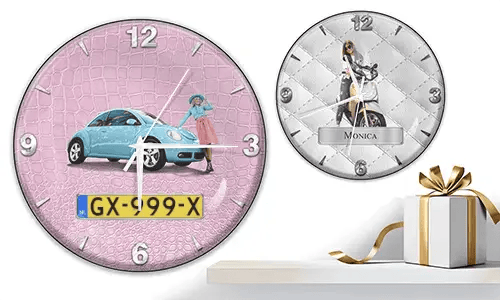Zwei Wanduhren mit weiblichen Figuren und Fahrzeugen: links mit schwarzem Auto vor lila Wellen, rechts mit rotem und schwarzem Auto, Rennflaggen und blauem Hintergrund