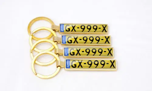 Llaveros dorados de placa de matrícula muestran números personalizados organizados juntos