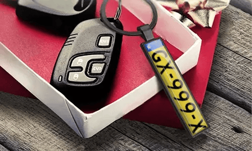 Llavero de placa de matrícula de metal muestra números grabados junto a las llaves del coche