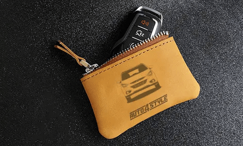 Two brown leather key pouches with zippers: one with motorcycle and plate 