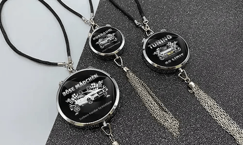Three black pendants with chains: each with car graphic and German tuning slogan on glittery surface