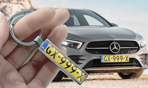 Llavero estilo placa de matrícula cómic, sostenido en la mano con la placa de coche correspondiente en el fondo