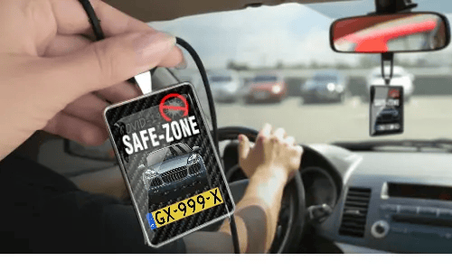 Auto-Safezone-Anhänger mit Carbon Hintergrund in der Hand Auto-Schutzraum-Anhänger