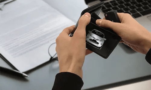 kreditkartenetui carbon mit Autosilouette neben Laptop carbon geldbörse