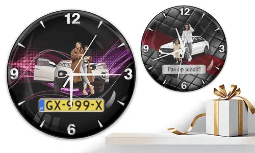 Two wall clocks with family car scenes: left with woman and child at white SUV over purple waves, right with white car and quilted red-black background