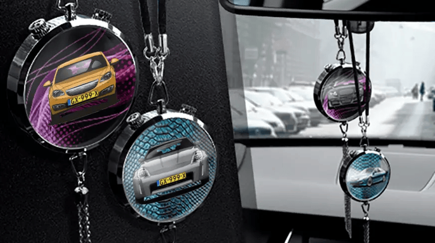 Two circular car air fresheners hanging from rearview mirror: left with black car, right with blue car