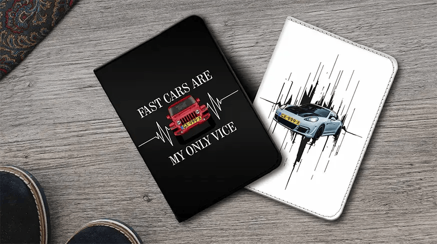 Two car-themed notebook covers on wooden surface: left black with red car and FAST CARS quote, right white with blue sports car and motion lines